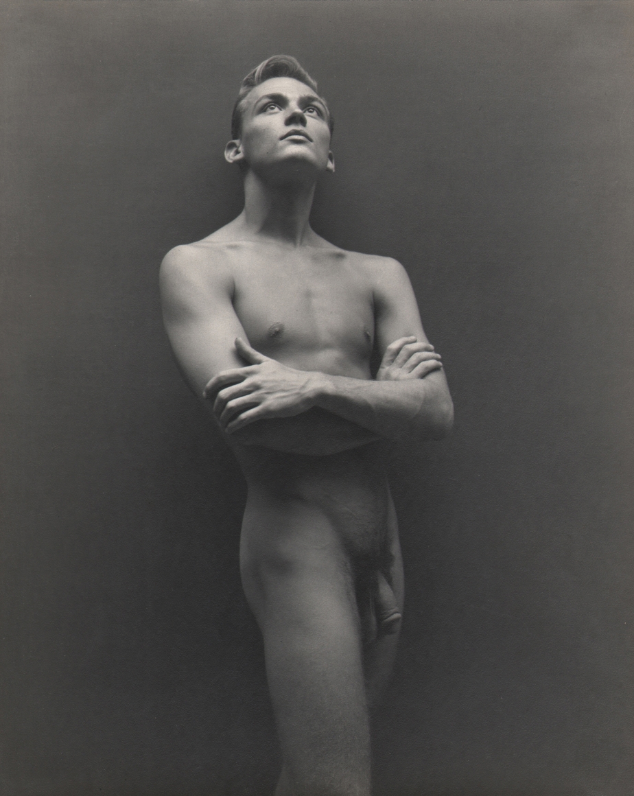 George Platt Lynes, Bill Harris, ​c. 1942. Male nude with arms crossed looking upward.