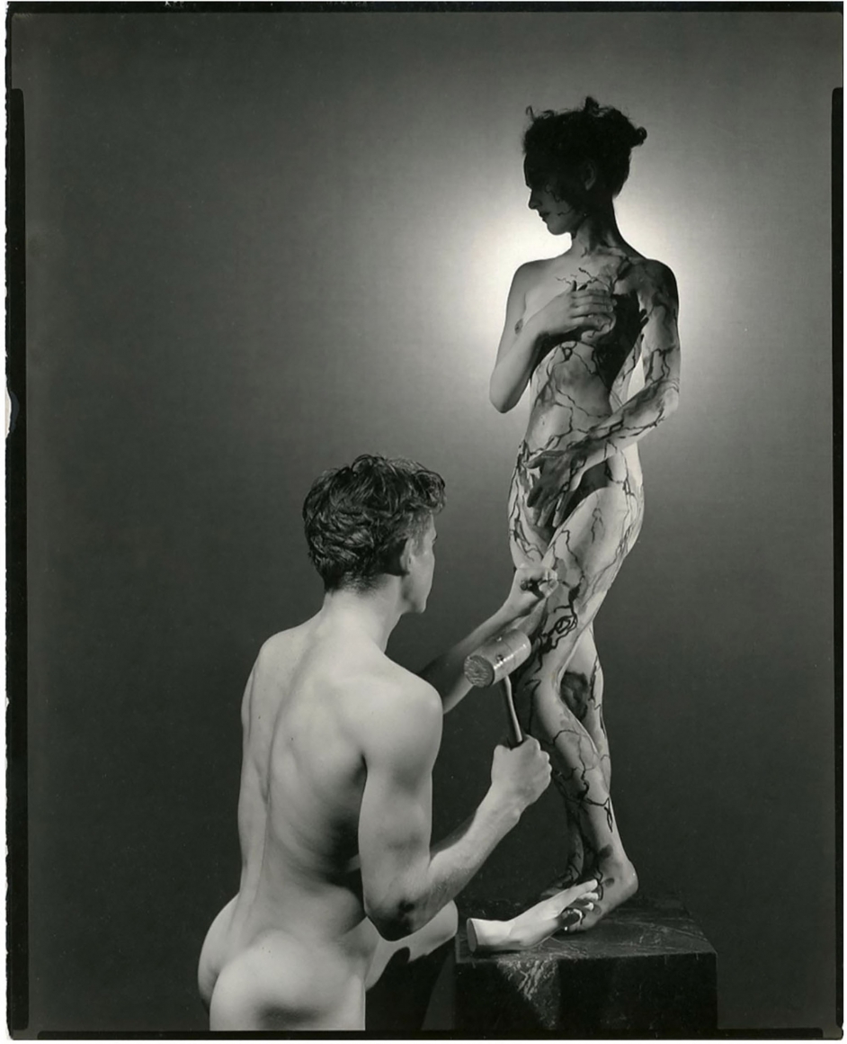 George Platt Lynes, Pygmaleon & Galatea, c. 1937. Male nude figure kneeling before a standing female nude. The male is posed with tools as if sculpting the female from marble.