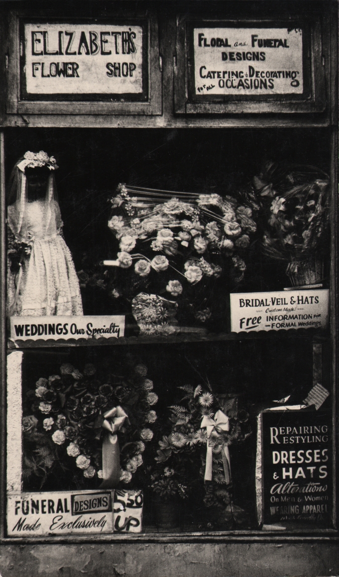 27. Beuford Smith, Harlem, NY, ​n.d. Window display of "Elizabeth's Flower Shop" with various floral arrangements on offer.