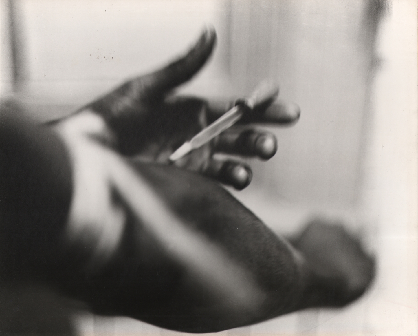 20. Shawn Walker, Drugs, Essence Magazine, ​1960s. Close up of a hand holding a needle to the opposite arm.