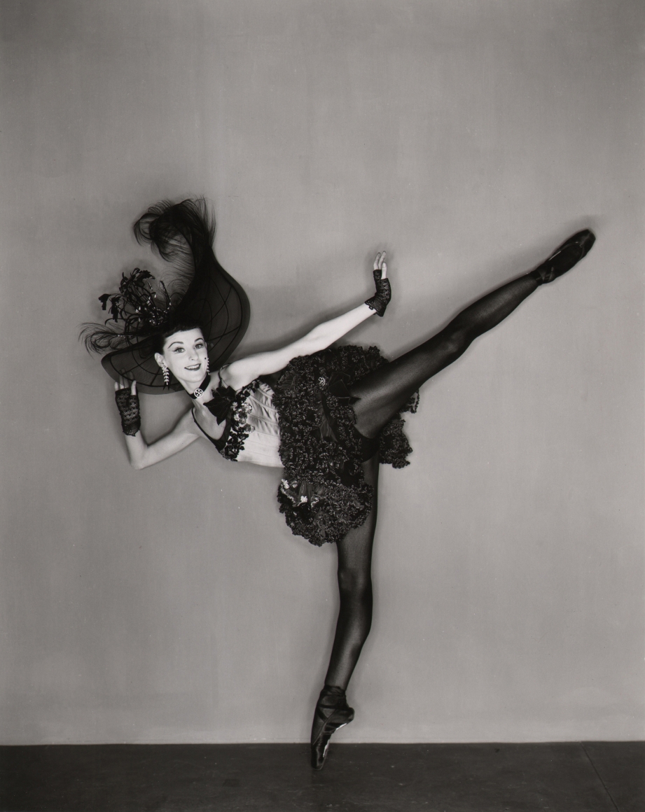 George Platt Lynes, Tanaquil LeClercq, Western Symphony, c. 1956. Dancer in black on pointe shoes kicks outward to the right.