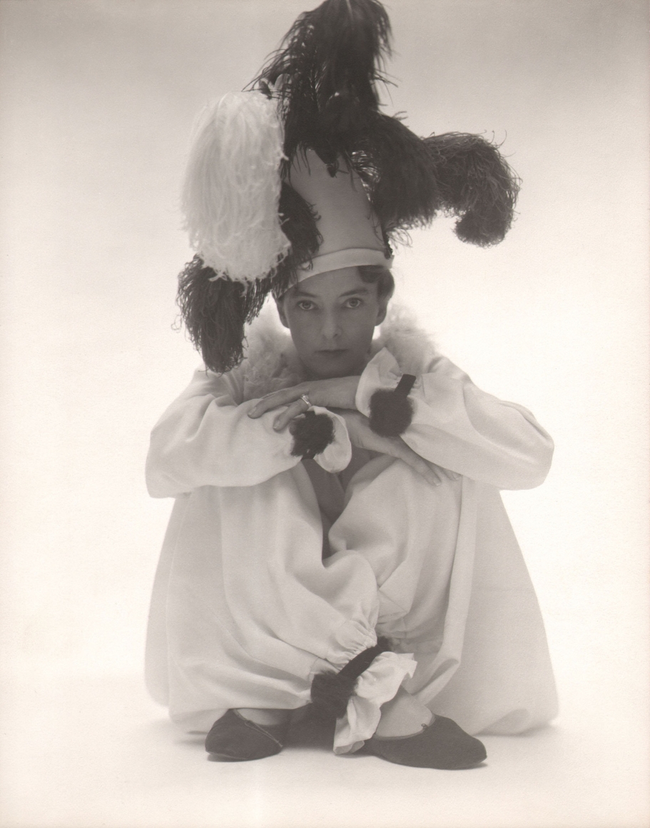 George Platt Lynes, Margaret French, c. 1940. Subject is seated on the studio floor in a clown costume.