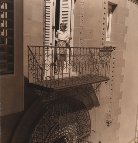 Louise Dahl-Wolfe, Morning in Havana, ​1941. A model stands in the doorway to a balcony, looking back into the interior.