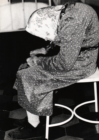02. Mario Giacomelli, Verrà la morte e avrà i tuoi occhi, 1966–1968. High contrast image. Side profile of a hunched old woman on a white stool.