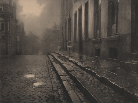09. Léonard Misonne, [title illegible], c. 1930. Wet, cobbled, residential street and steps in soft light. Sepia-toned print.