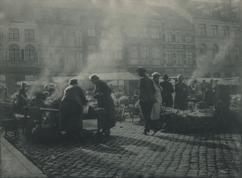06. Léonard Misonne, Untitled, c. 1937. Many figures on a cobbled market street with steam rising from various booths. Gray/green-toned print.