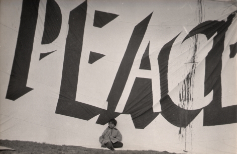 8. LeRoy Henderson, Central Park Anti-Vietnam War Rally, 1968. Young child sits against large banner that reads "PEACE" and fills the frame.