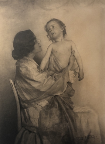 02. Gertrude Käsebier, Adoration, ​1897. A seated woman in profile holds a small child upright on her lap.