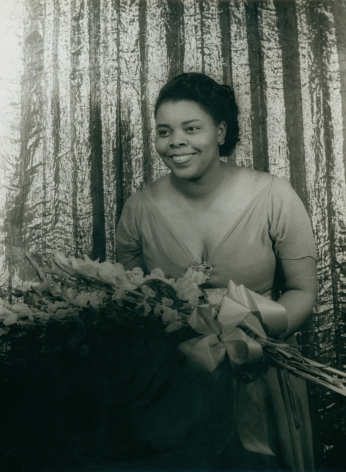 09. Carl Van Vechten, Carol Brice, ​1947. Subject stands, smiling towards the left of the frame, holding a large bouquet.
