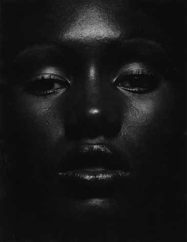 07. Anthony Barboza, Grace Jones, ​1970s. Close up of the model's dimly-lit face, eyes looking to the camera and lips slightly parted.