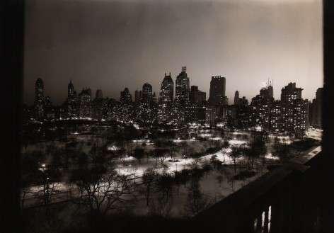 Paul J. Woolf, Central Park & 59th Street, ​c. 1936. Night time cityscape with Central Park in the foreground and tall buildings in the background.