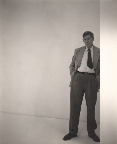 George Platt Lynes, W.H. Auden, ​1947. Subject stands on the right of the frame leaning against a white wall.