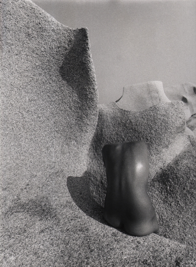 Pino Dal Gal, Capo Testa (Sardinia), ​1977. Abstracted nude torso photographed from behind against a stone landscape.